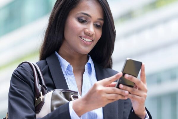 Woman holding and looking down at smartphone.