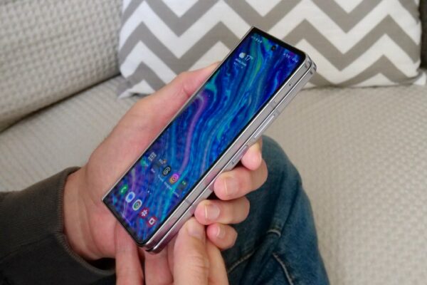 A person holding the Samsung Galaxy Z Fold 5, seen from the side. A person holding the Samsung Galaxy Z Fold 5, seen from the side.