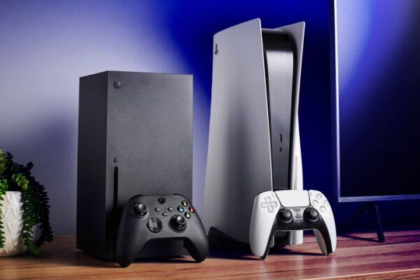 Living room with Microsoft Xbox Series X (L) and Sony PlayStation 5 home video game consoles alongside a television and soundbar. Living room with Microsoft Xbox Series X (L) and Sony PlayStation 5 home video game consoles alongside a television and soundbar.
