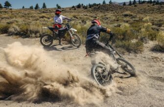 A rider sitting on a Zero XE watching another rider doing donuts in the dirt on a Zero XB.