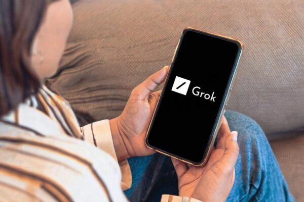 человек смотрит на смартфон с логотипом grok ai