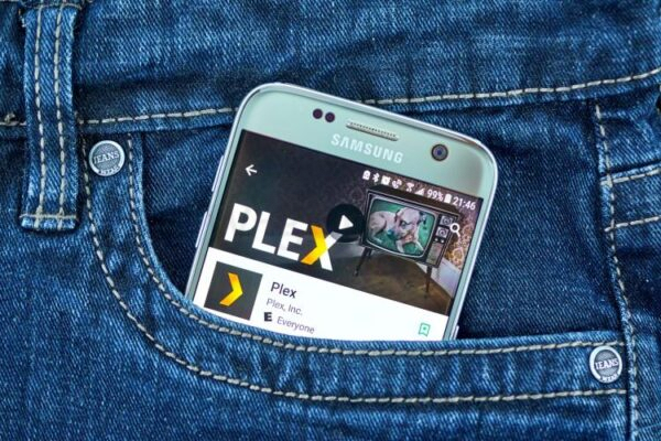 plex на экране смартфона в кармане джинсов