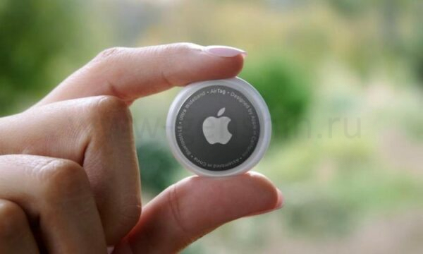 Человек держит Apple AirTag.