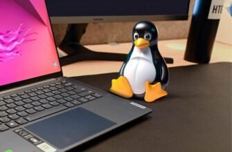 Маскот Linux на столе рядом с ноутбуком.