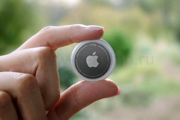 Человек держит Apple AirTag.