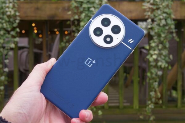 Человек держит OnePlus 13.