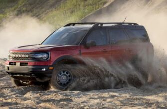 Передний вид красного внедорожника Ford Bronco Sport 2021 года, который движется по песку.