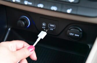 Рука подключает USB-кабель в порт на приборной панели автомобиля