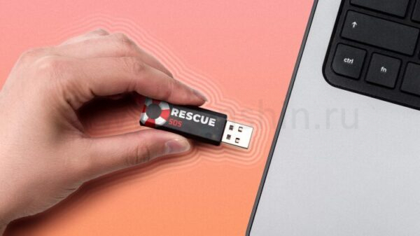 Hand inserting a USB flash drive labeled 'Rescue SOS' into a laptop.