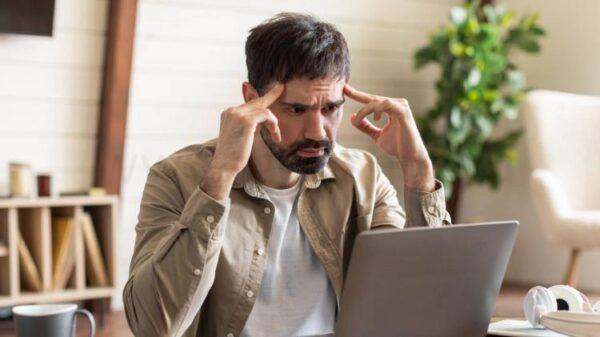 A thinking man lost in thought at a desk.