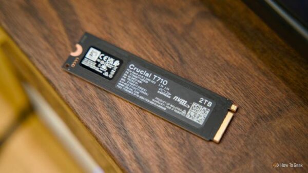 The back of the Crucial T710 NVMe SSD sitting on a walnut shelf.