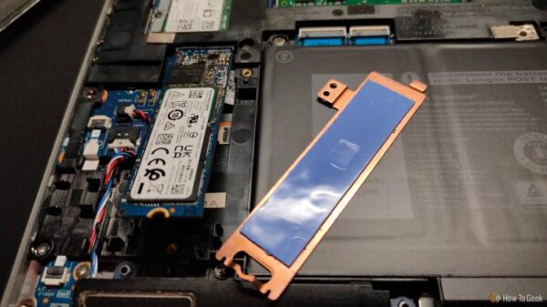 Copper NVMe heatsink and NVMe SSD inside a laptop.