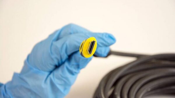 Рука в перчатке держит конец очень длинного HDMI-кабеля.