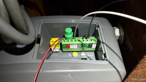 A garage door opener with wires connected to various terminals.