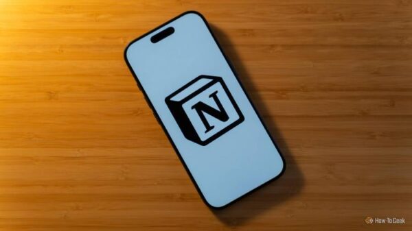 An iPhone 17 Pro with the Notion logo on a white background sitting on a bamboo desk.
