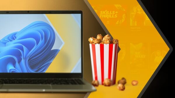 Ноутбук на Windows 11 рядом с ведёрком попкорна, логотип Plex и размытая заставка потокового видео на фоне.