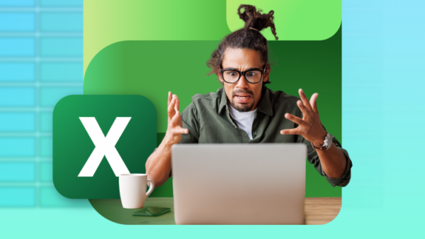 A man looking frustrated while holding a laptop running Excel.