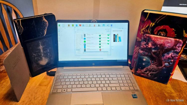 Calibre, open in a laptop , surrounded by various kindle devices and books