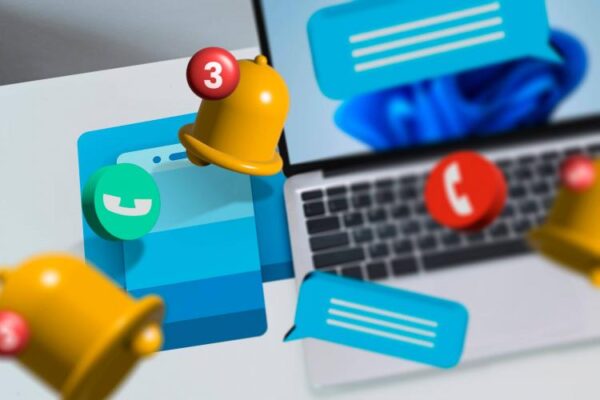 Ноутбук на столе с логотипом Phone Link и уведомлениями.