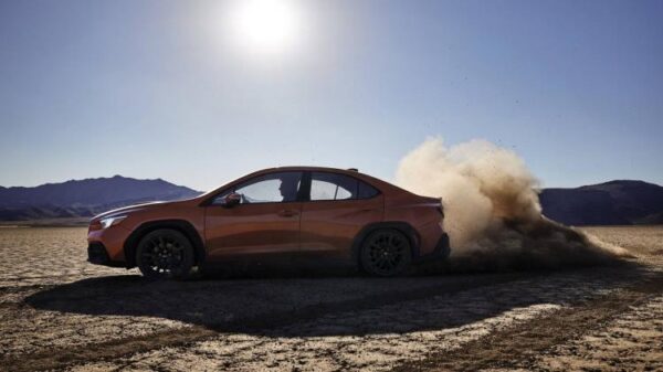 Side profile action shot of a 2022 Subaru WRX kicking up dirt