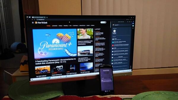 A phone next to a monitor showing the HTG page on Samsung Browser